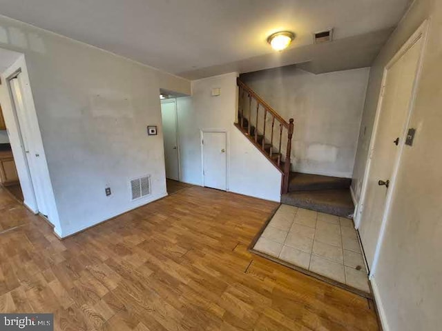 foyer with stairs, wood finished floors, and visible vents