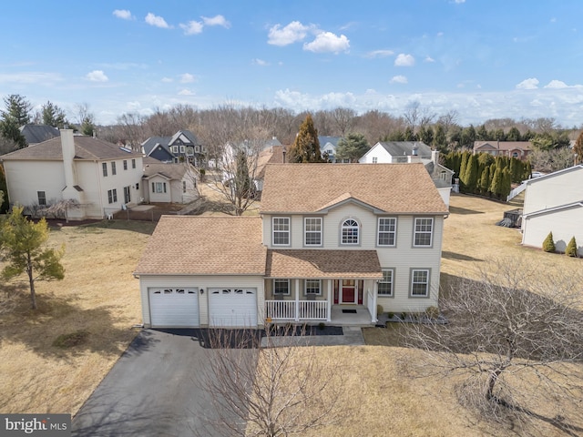 view of front of house featuring aphalt driveway, an attached garage, covered porch, a shingled roof, and a residential view