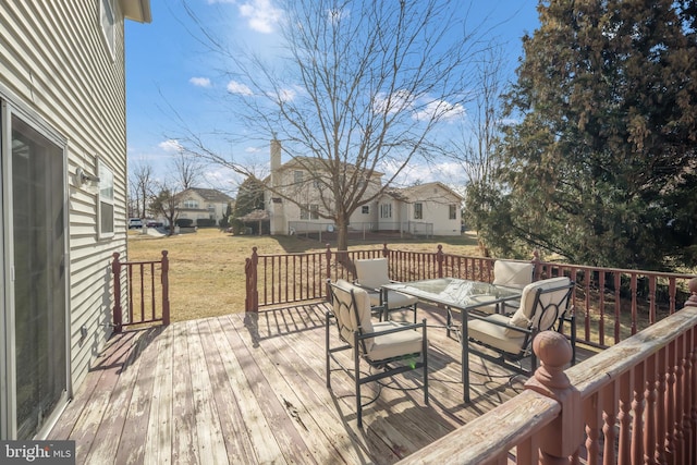 wooden deck featuring outdoor dining space, a residential view, and a yard