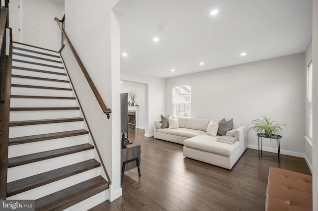 living room with dark wood-style flooring, a fireplace, recessed lighting, stairway, and baseboards