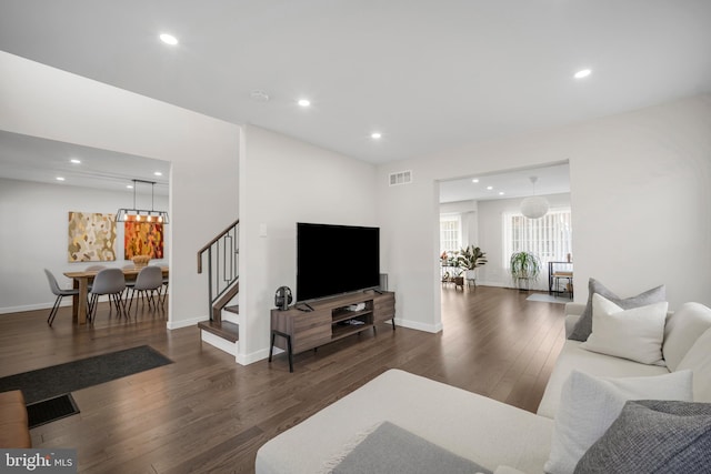 living room featuring stairs, visible vents, dark wood-style flooring, and recessed lighting