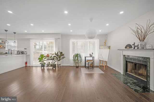 sitting room featuring a tiled fireplace, dark wood finished floors, and recessed lighting