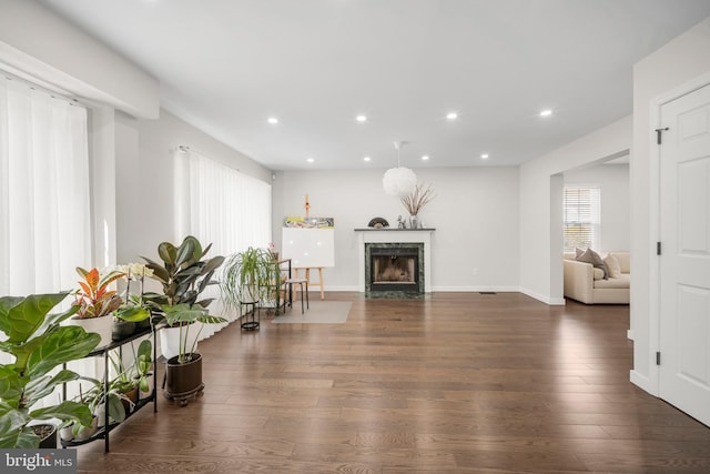 living room with baseboards, a premium fireplace, wood finished floors, and recessed lighting