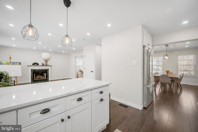 kitchen with recessed lighting, high end refrigerator, a high end fireplace, visible vents, and dark wood-style floors