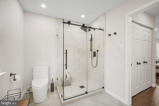 ensuite bathroom with toilet, recessed lighting, baseboards, a shower stall, and ensuite bath