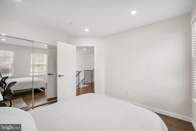 bedroom featuring a closet, baseboards, wood finished floors, and recessed lighting