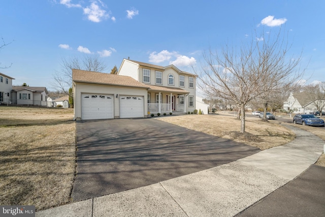 view of front facade featuring an attached garage, a porch, a front lawn, and aphalt driveway