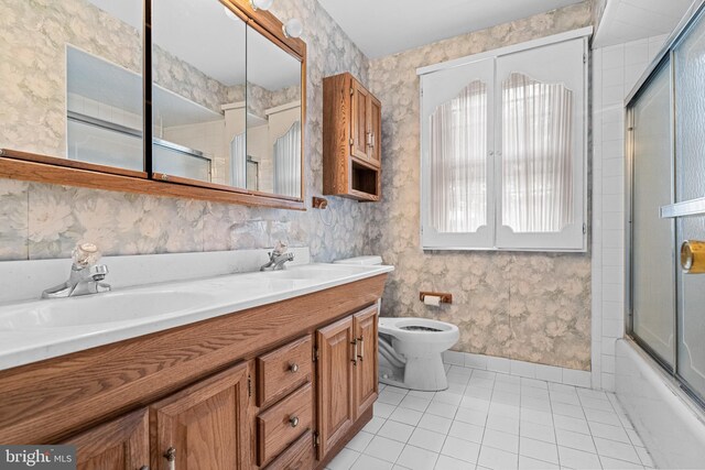 full bathroom featuring tile patterned flooring, a sink, toilet, and wallpapered walls