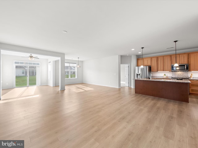 unfurnished living room featuring light wood-type flooring, baseboards, a ceiling fan, and recessed lighting