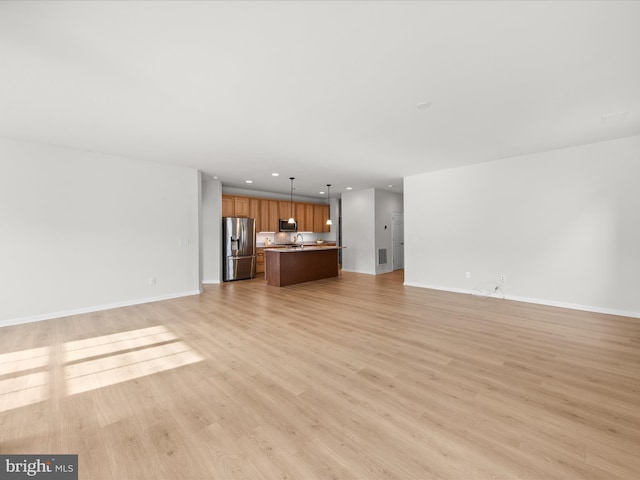 unfurnished living room with baseboards, light wood-style flooring, and recessed lighting