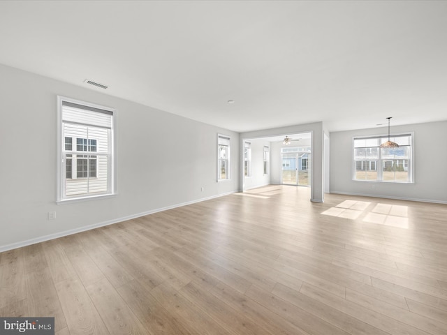 unfurnished living room with a ceiling fan, light wood-style flooring, visible vents, and baseboards