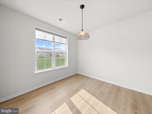 spare room with light wood-style floors, baseboards, and visible vents