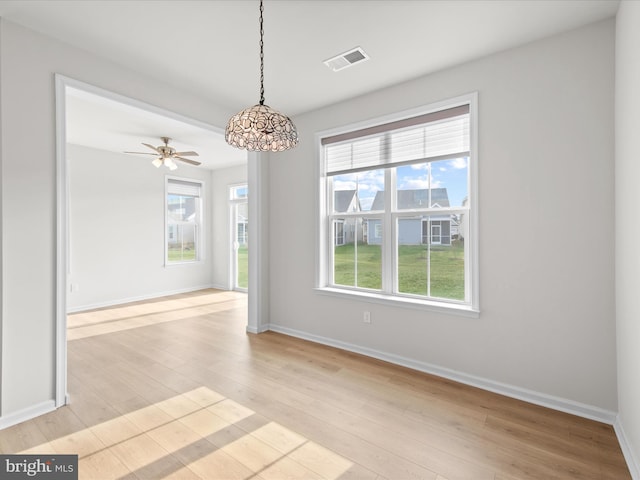 unfurnished dining area with light wood-style floors, visible vents, baseboards, and a ceiling fan