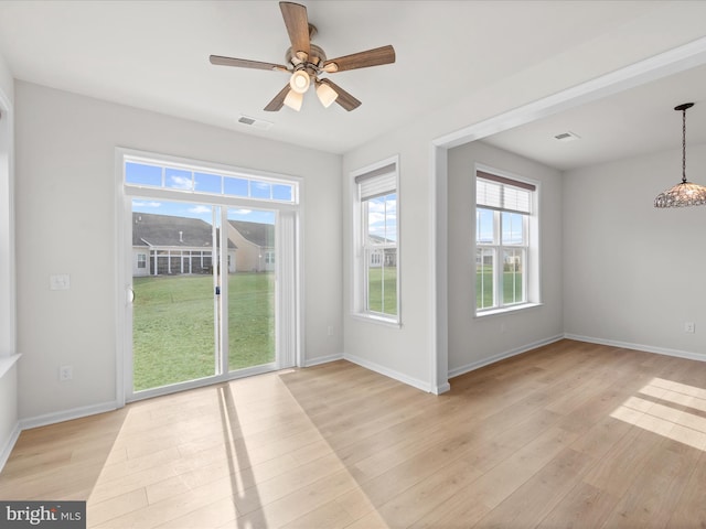 interior space featuring light wood finished floors, baseboards, and visible vents