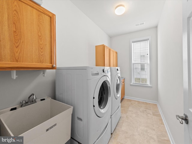 laundry room featuring cabinet space, visible vents, a sink, washer and dryer, and baseboards