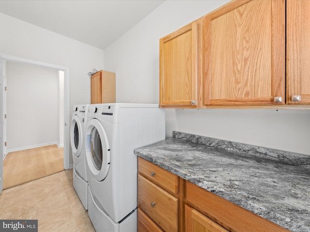 washroom featuring cabinet space, washing machine and clothes dryer, and light tile patterned floors