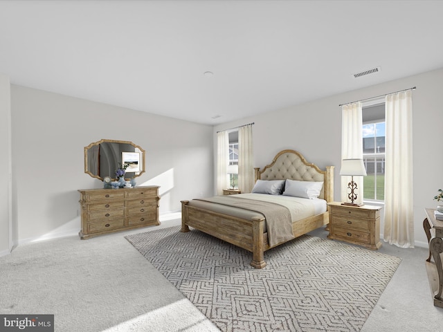 bedroom featuring light colored carpet and visible vents