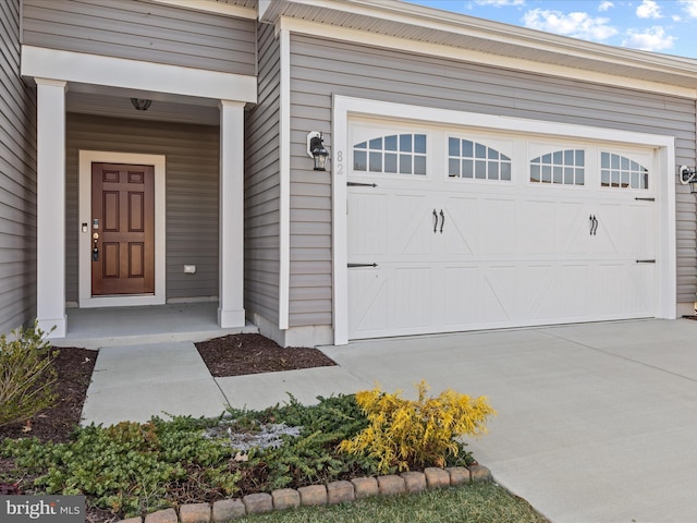 view of exterior entry featuring concrete driveway