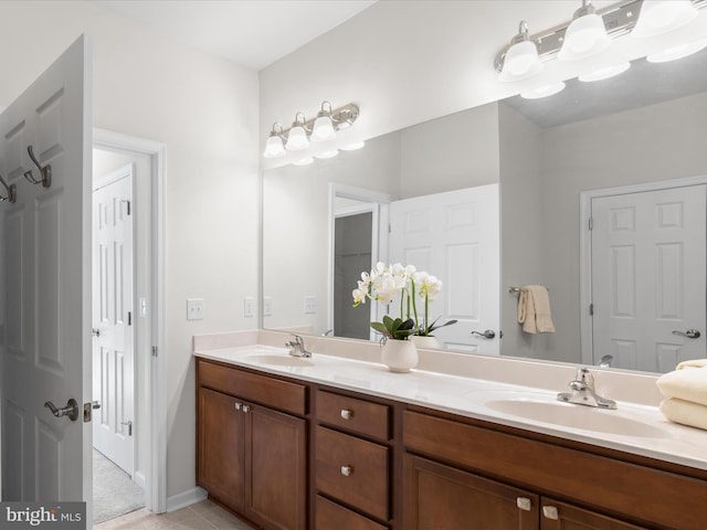 full bathroom featuring double vanity, a sink, and tile patterned floors