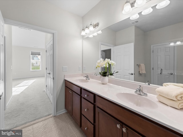 full bathroom featuring double vanity, baseboards, visible vents, and a sink