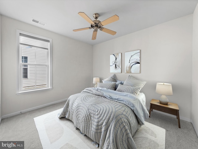 bedroom featuring light carpet, ceiling fan, visible vents, and baseboards