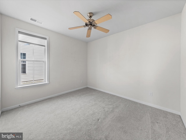 spare room featuring ceiling fan, carpet floors, visible vents, and baseboards