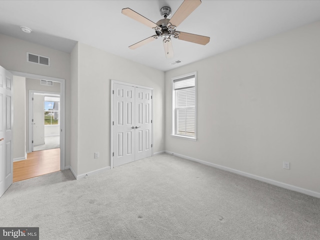 unfurnished bedroom featuring carpet floors, multiple windows, visible vents, and baseboards