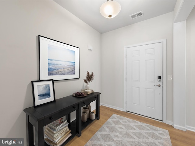 entrance foyer with visible vents, light wood-style flooring, and baseboards