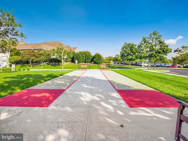 view of home's community featuring a yard and shuffleboard