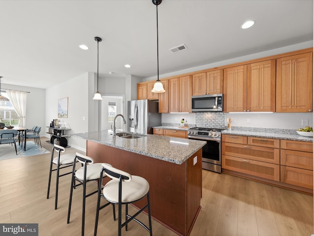 kitchen featuring light wood-type flooring, visible vents, stainless steel appliances, and a sink