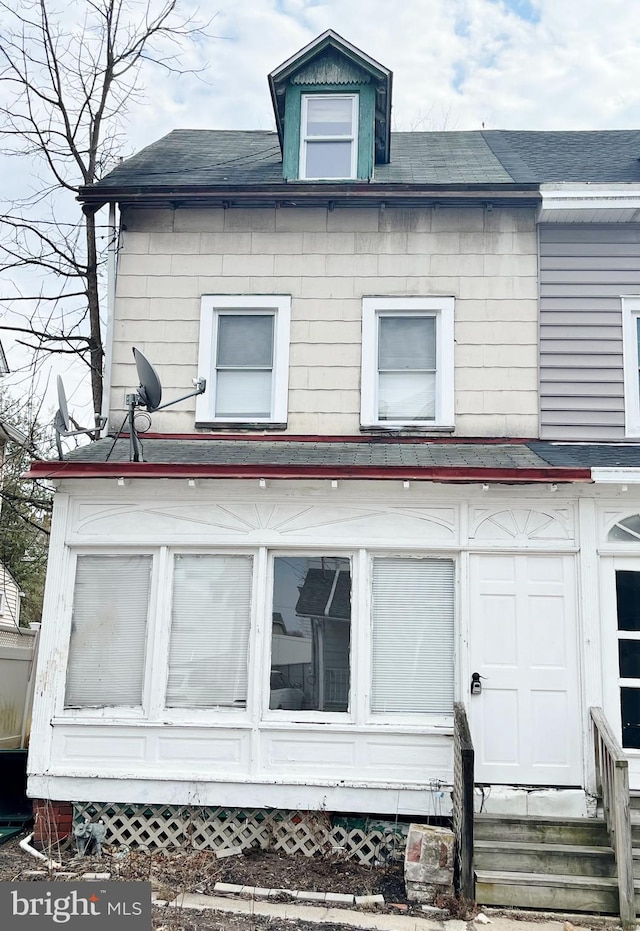 view of property exterior featuring entry steps and roof with shingles