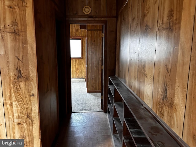 corridor with wood walls and baseboard heating