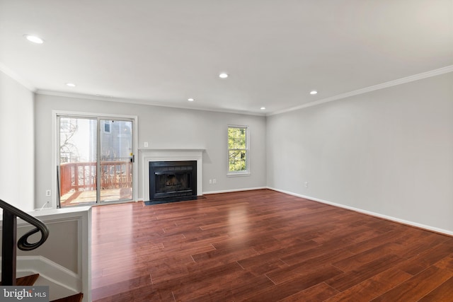 unfurnished living room with a fireplace with flush hearth, dark wood-type flooring, recessed lighting, crown molding, and baseboards