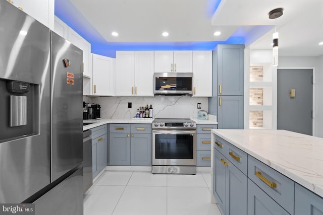 kitchen featuring tasteful backsplash, appliances with stainless steel finishes, light stone counters, decorative light fixtures, and recessed lighting