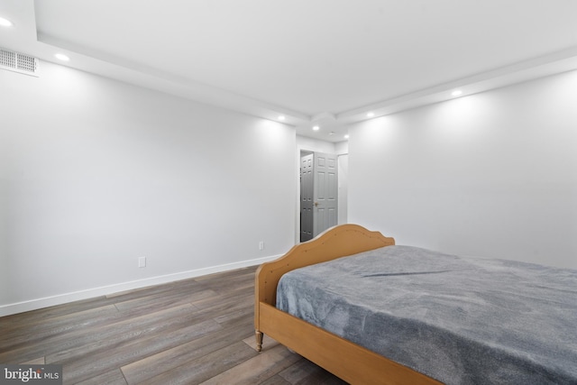 bedroom featuring baseboards, visible vents, wood finished floors, and recessed lighting