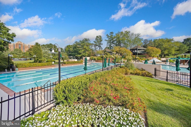 surrounding community with a yard, a pool, and fence