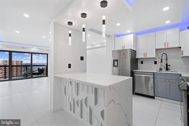 kitchen featuring light tile patterned floors, decorative backsplash, light stone counters, stainless steel appliances, and a sink