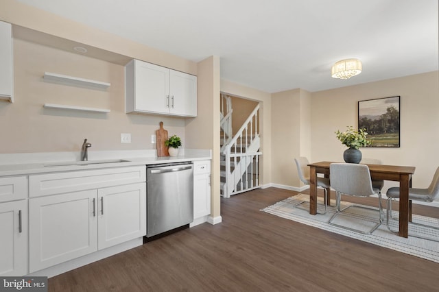 kitchen with a sink, stainless steel dishwasher, dark wood finished floors, white cabinetry, and light countertops