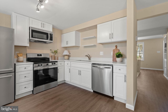 kitchen with a sink, appliances with stainless steel finishes, white cabinets, and light countertops