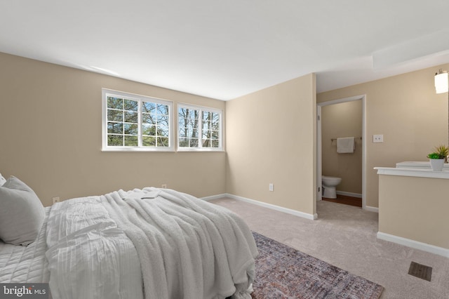 carpeted bedroom with baseboards and ensuite bathroom