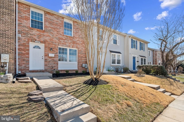 multi unit property featuring brick siding and a front yard