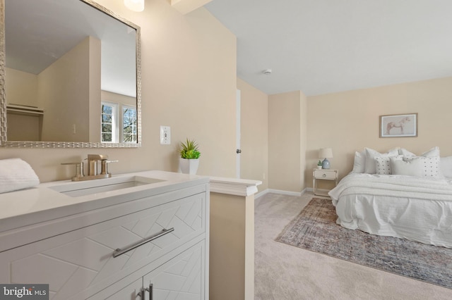 bedroom featuring light colored carpet, baseboards, and a sink