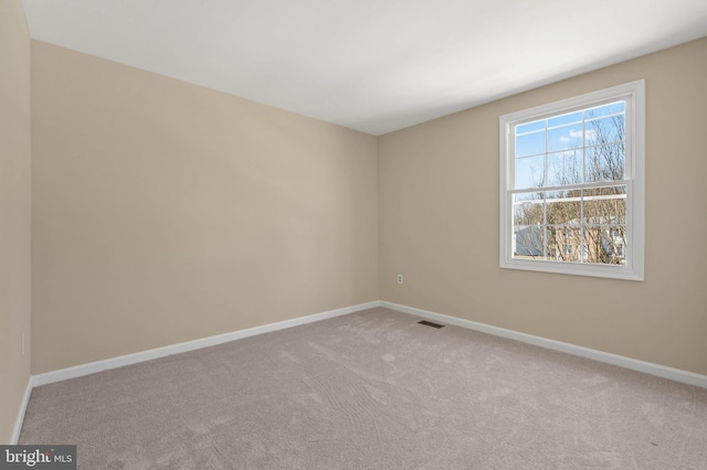 carpeted empty room with visible vents and baseboards