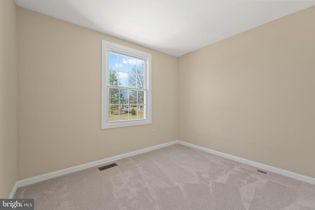 unfurnished room featuring visible vents, carpet, and baseboards