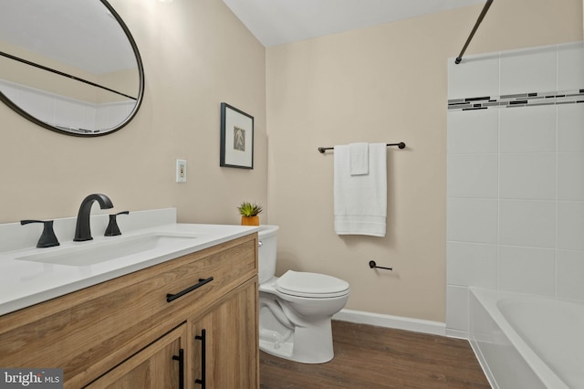 full bath with toilet, shower / washtub combination, wood finished floors, baseboards, and vanity