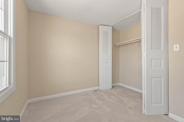 unfurnished bedroom featuring a closet, baseboards, and carpet