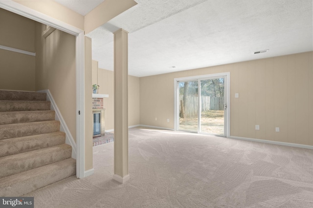 stairs featuring visible vents, baseboards, a fireplace, and carpet flooring