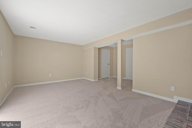 spare room featuring baseboards, visible vents, and light carpet