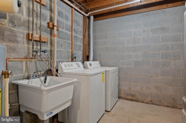 laundry room featuring washer and clothes dryer, laundry area, and a sink