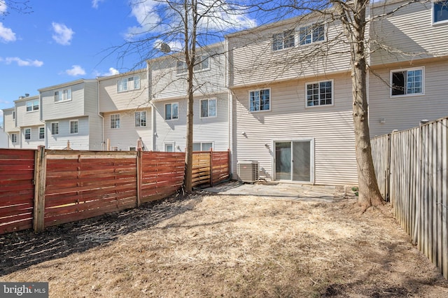 rear view of property featuring cooling unit, a residential view, and a fenced backyard